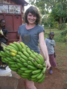 Praktikantin Luisa hält eine Bananenstaude fest